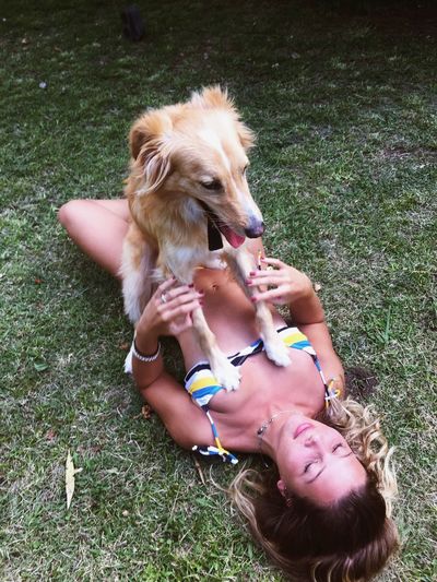 Woman with dog lying on grass 