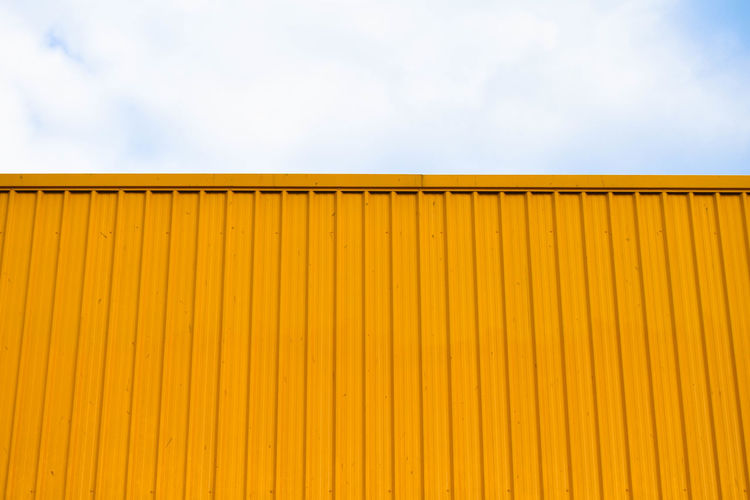 Low angle view of yellow building against sky