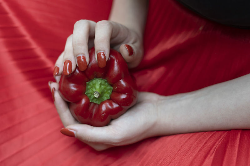 Close-up of woman hand holding red fruit
