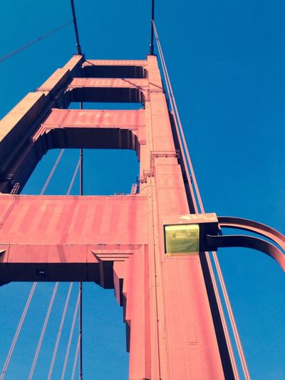 Low angle view of golden gate bridge against blue sky