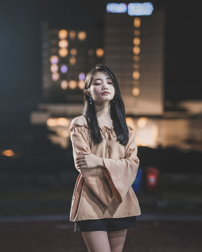 Young woman standing outdoors at night