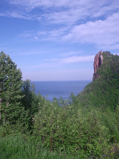 Scenic view of cliff and sea against sky