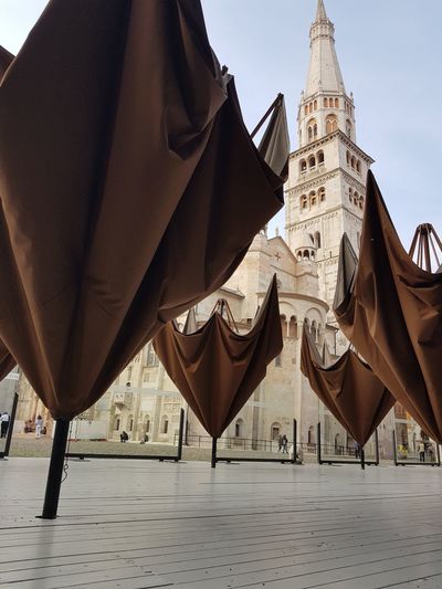Upside down big brown umbrellas with an historic building behind as background