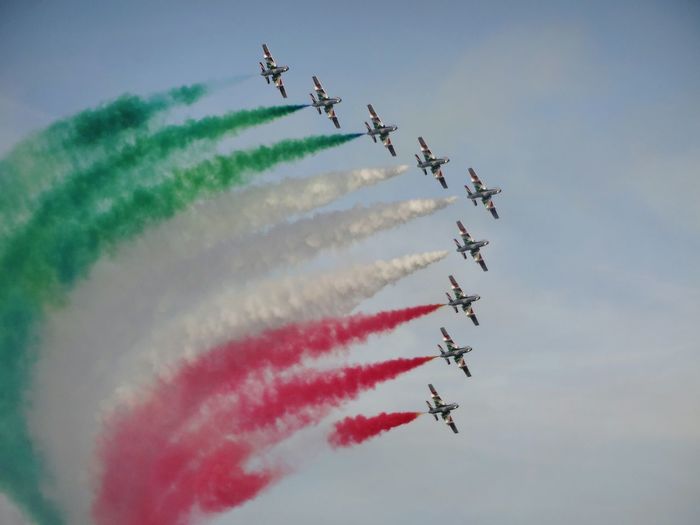 Low angle view of italian air force planes flying against sky
