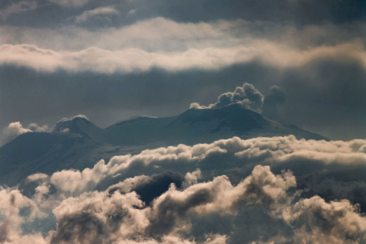 Scenic view of snowcapped mountain against cloudy sky during sunset