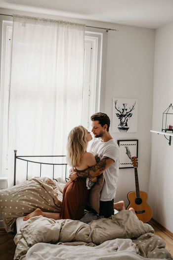 Couple kissing on bed at home