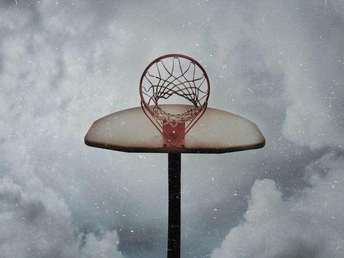 Close-up of basketball hoop against sky during winter