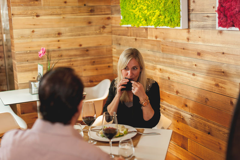 High angle view of man and woman at table against wooden wall in restaurant