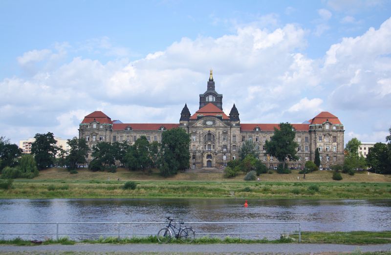 View of castle by river against buildings