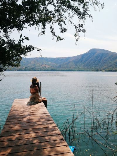 Rear view of man on lake against sky