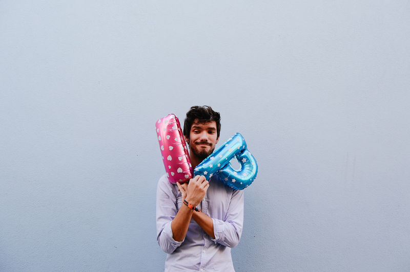 Portrait of young adult holding balloons