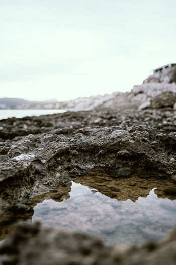 Water in rock formation against sky