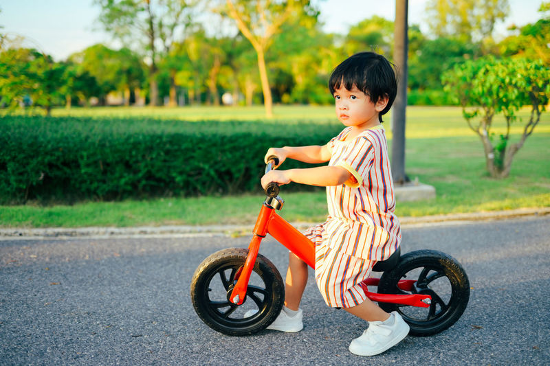 Boy playing with push scooter on road