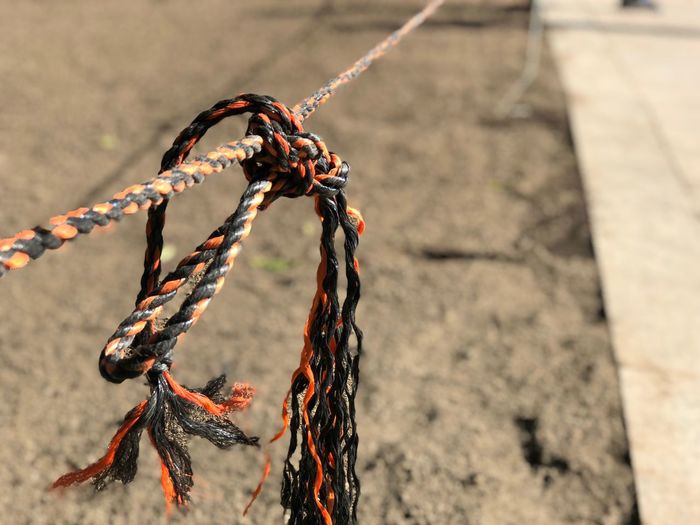 Close-up of rope tied up on sand
