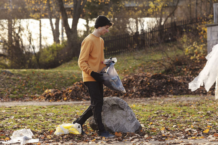 Male volunteer collecting garbage while walking in park