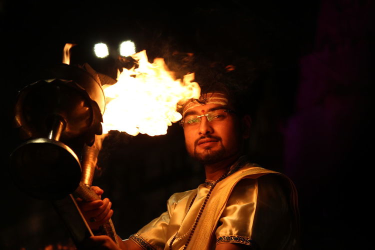 Portrait of man holding oil lamp at night