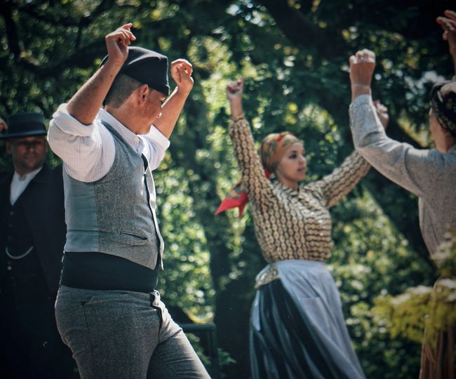 People dancing against trees in park