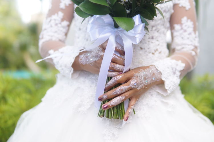 Close-up of woman holding bouquet of white flower