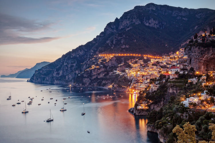 High angle view of sea by illuminated buildings at positano
