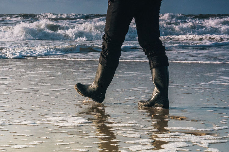 Low section of woman wading in sea