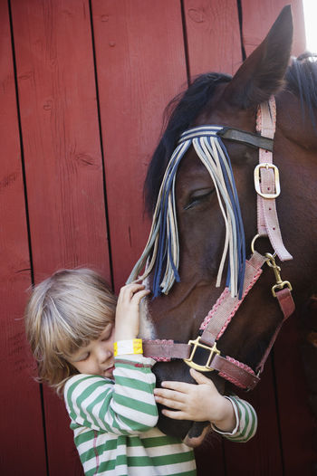 Boy hugging horse