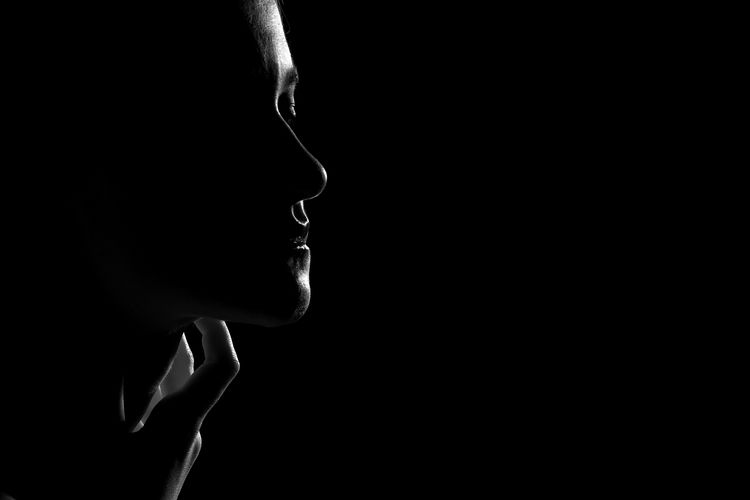 Sad female profile silhouette on black background with copy space, closed eyes, monochrome
