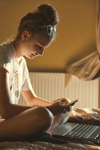 Midsection of woman using mobile phone at home