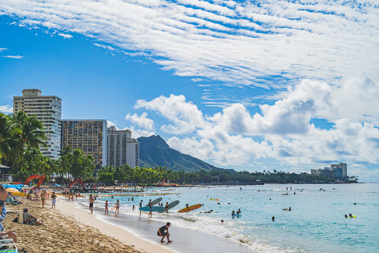 People at beach against sky