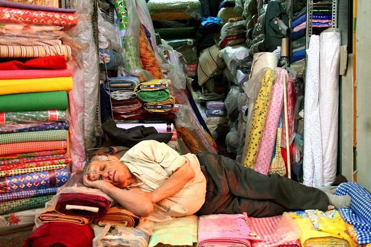 Man sleeping on fabrics for sale