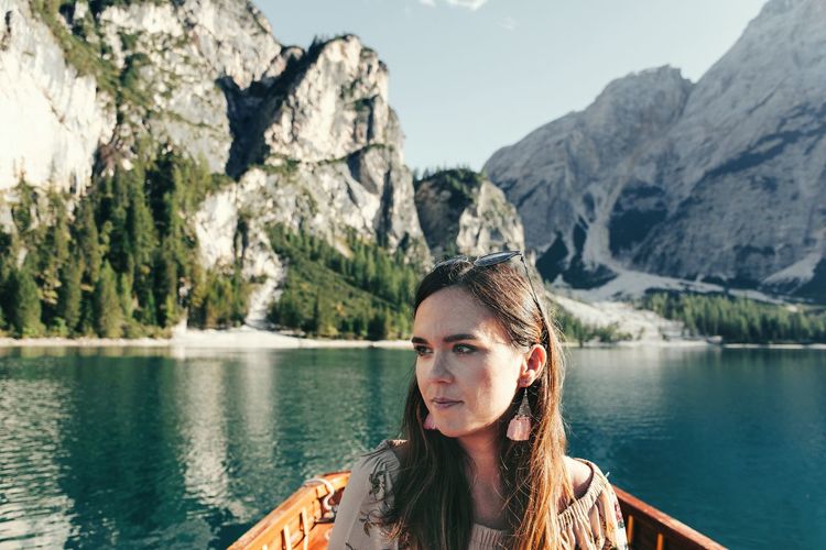 Portrait of woman by lake against mountains