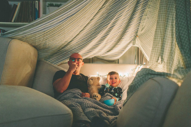 Father and son relaxing on sofa at home