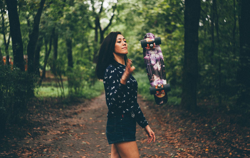 Young woman with skateboard at park