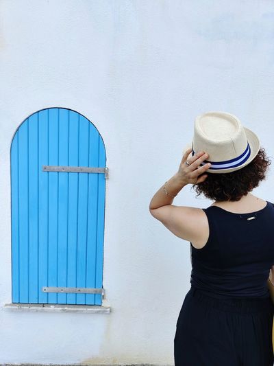 Rear view of woman standing against wall