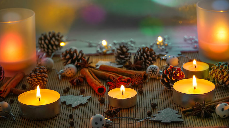 Close-up of burning tea lights decorations and spices on table