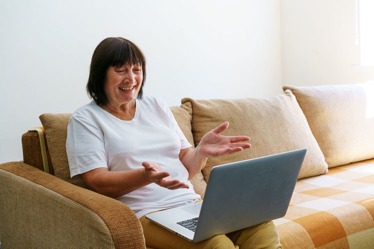 Elderly mature woman using wireless laptop apps