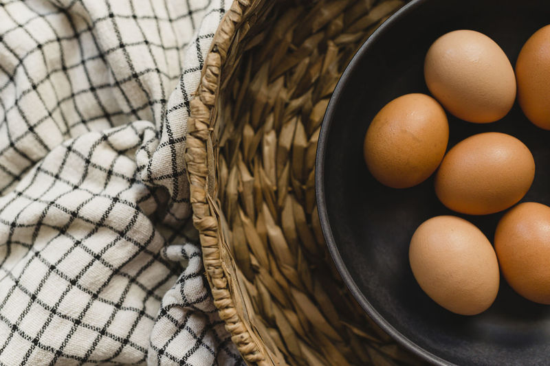 Organic brown eggs in brown bowl and basket