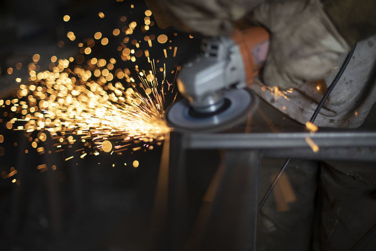 Broom processing. grinding of steel. man cutting steel profile. works in workshop.