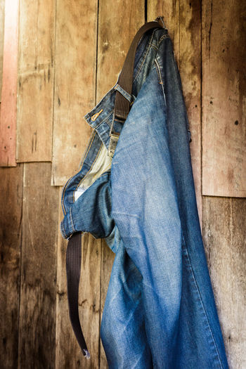 Midsection of man hanging against blue wall