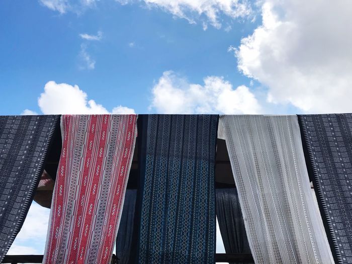 Low angle view of textile hanging against sky