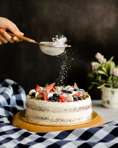 A whole red velvet cake, topped with berries. the perfect dessert for birthdays and celebrations.  