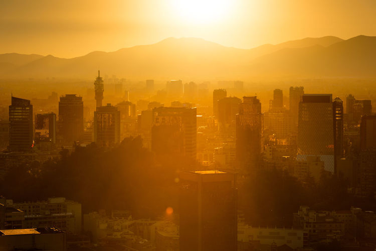 Aerial view of buildings in city during sunset