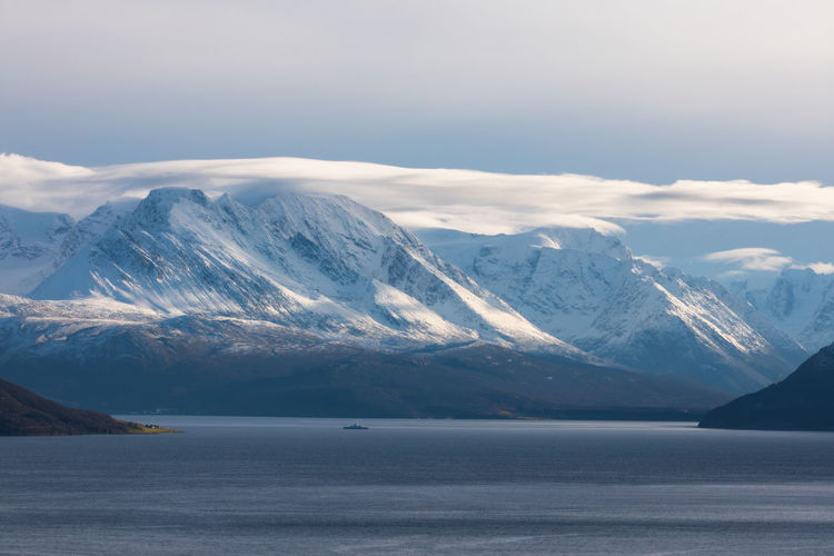 Scenic view of snowcapped mountains and sea against sky