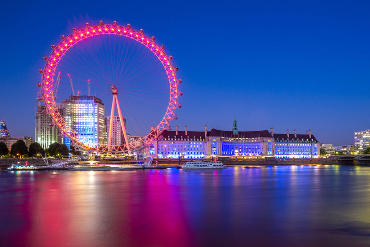 Illuminated ferris wheel in city at night