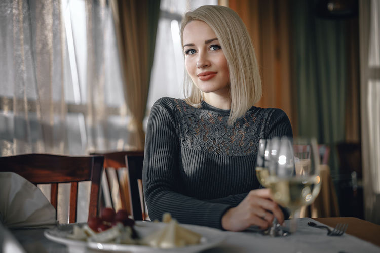 Portrait of young woman sitting at restaurant table