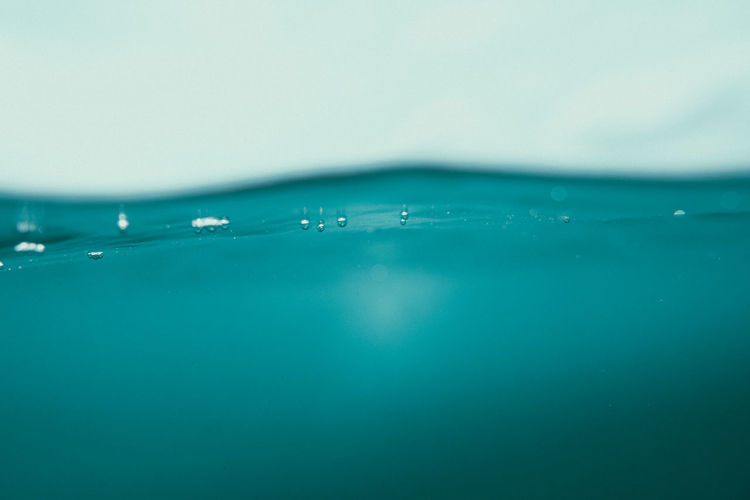 Close-up of bubbles over sea against blue background