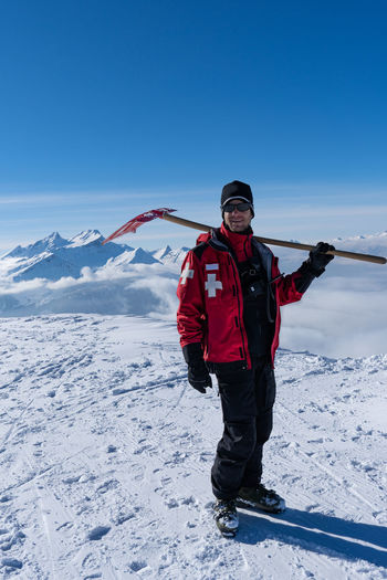 Full length of man standing on snowcapped mountain against sky