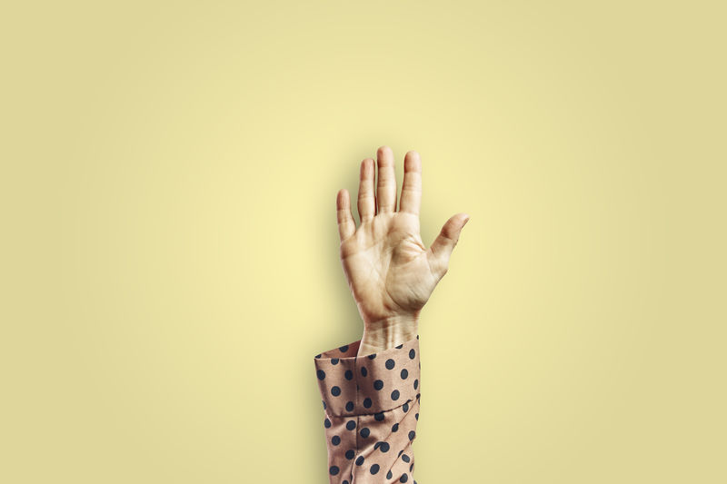 Woman arm gesturing with open hand isolated on yellow background. gesture concept