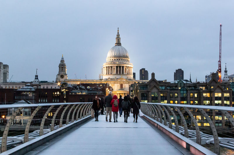Rear view of people walking on millennium bridge with view of st.paul's cathedral