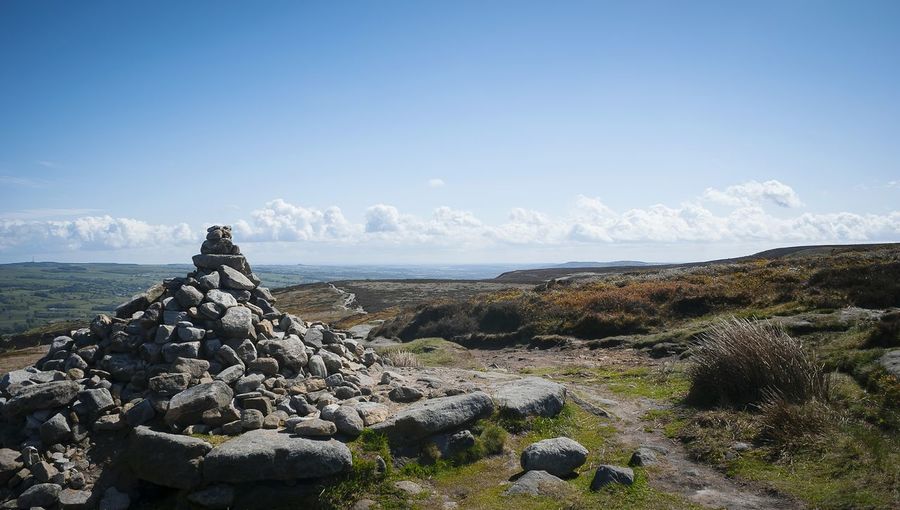 Heap of stones with scenic view ilkley moor against sky