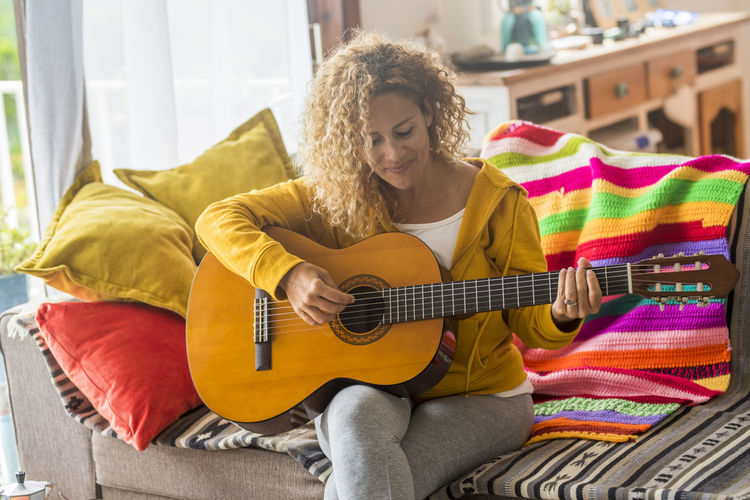 Portrait of young woman playing guitar
